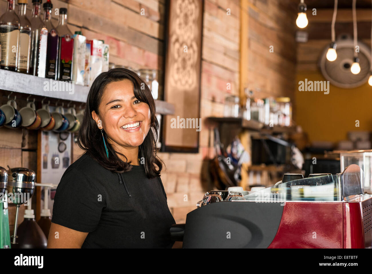 Smiling Hispanic woman working in coffee shop Stock Photo