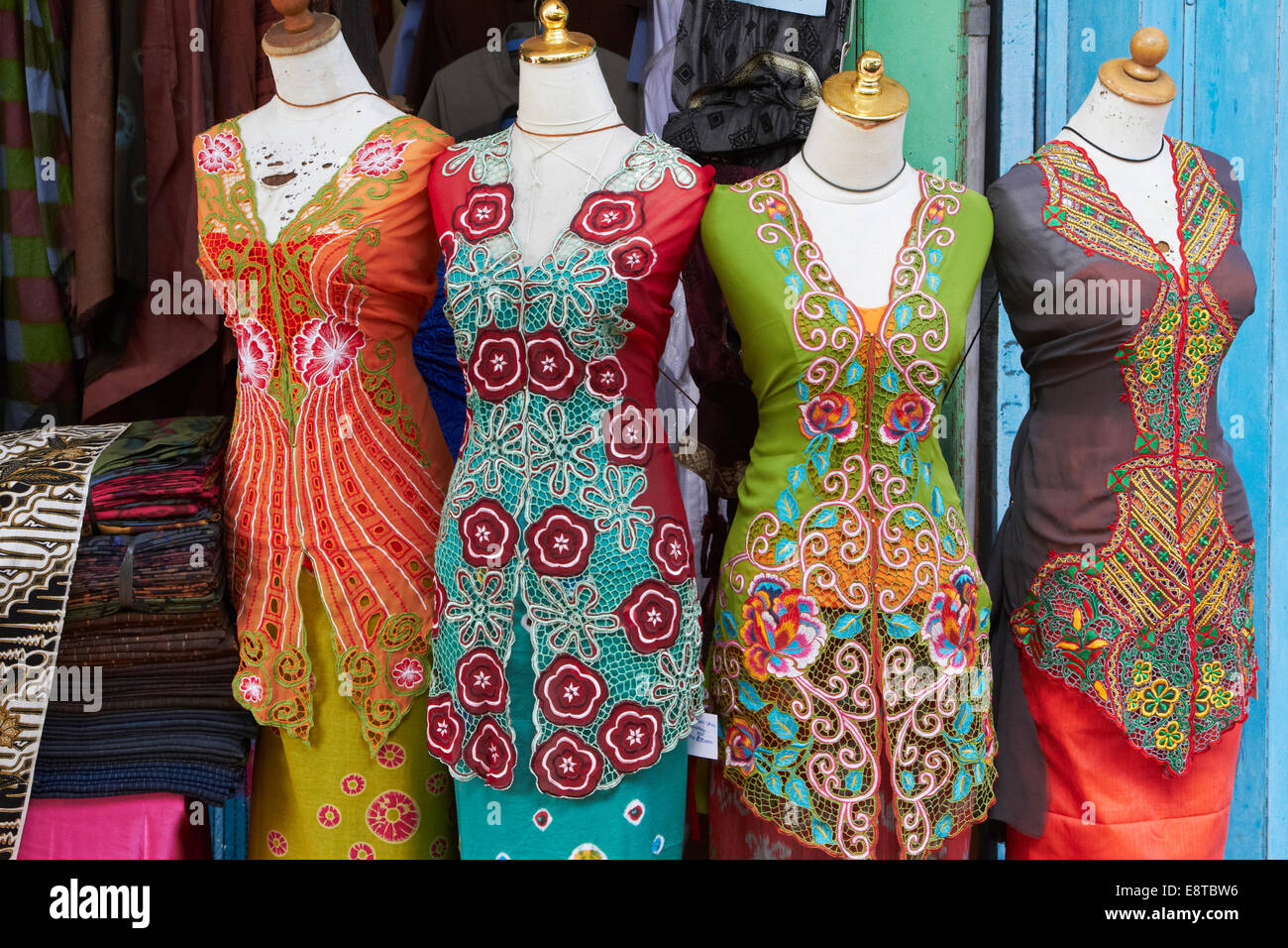 Traditional sarongs on mannequins at market Stock Photo