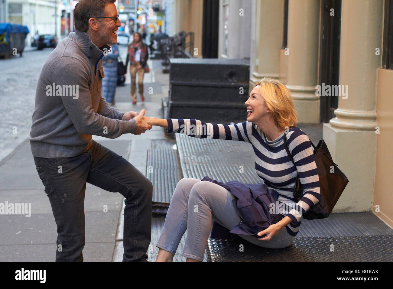 Caucasian couple playing on city sidewalk, New York City, New York, United States Stock Photo