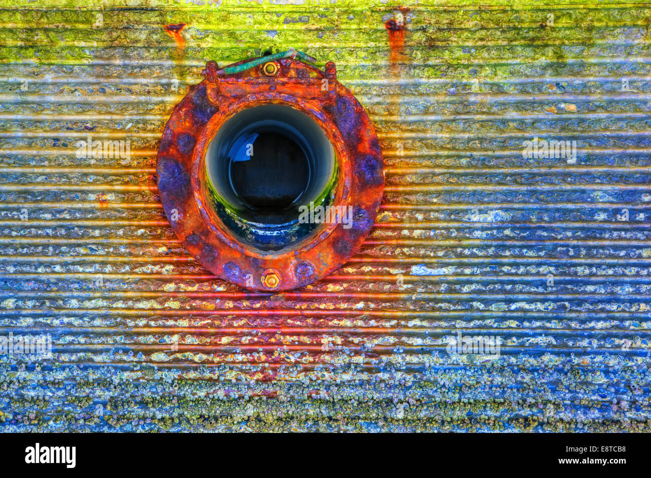 Close up of circular window on rusting wall Stock Photo