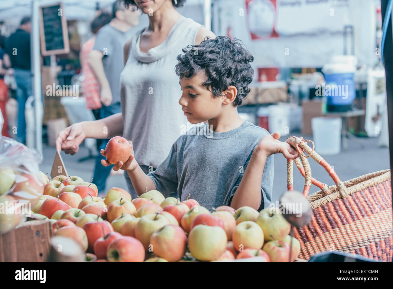 Mixed race boy shopping with mother at farmers market Stock Photo