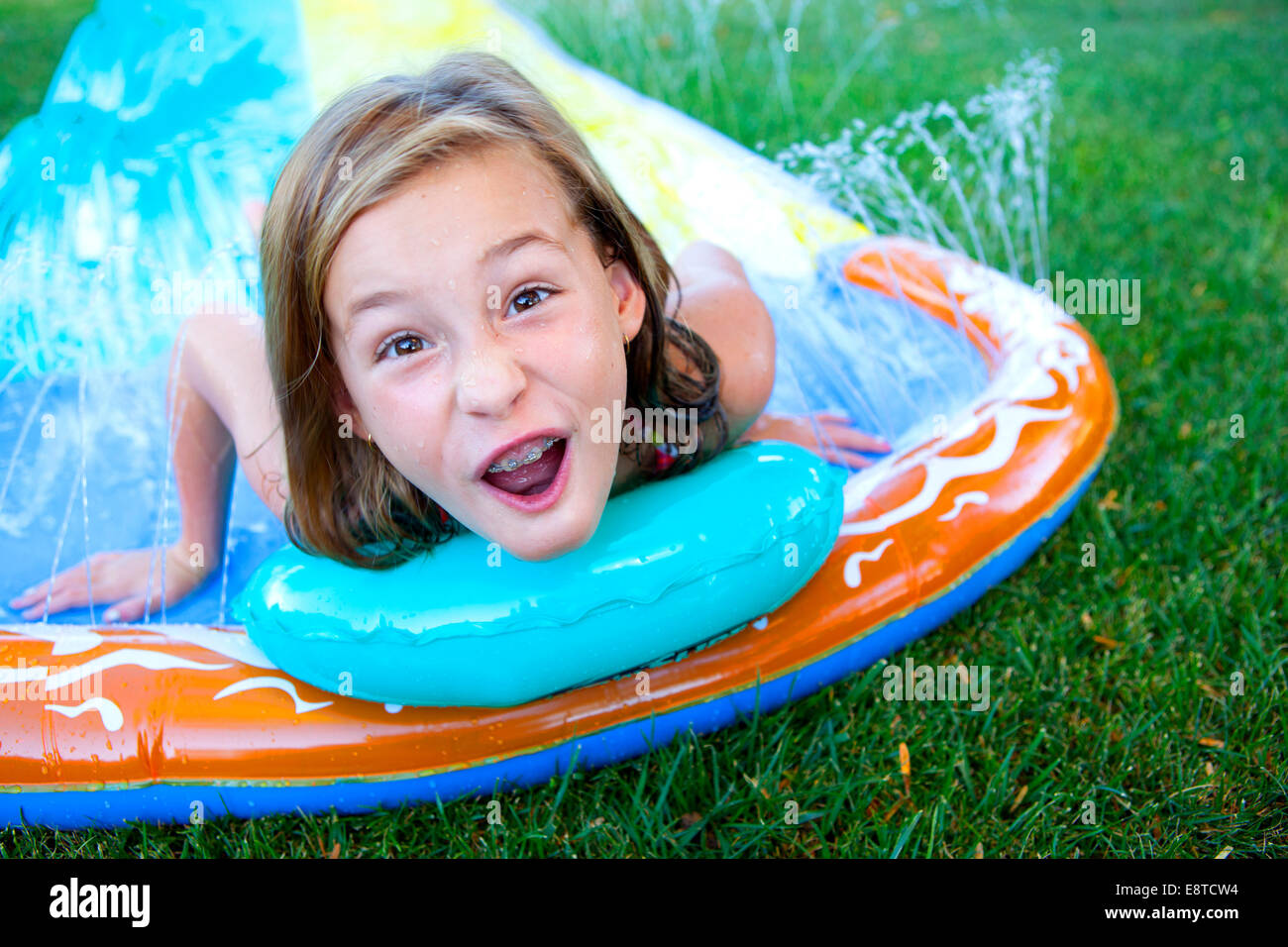 Caucasian girl smiling on water slide Stock Photo