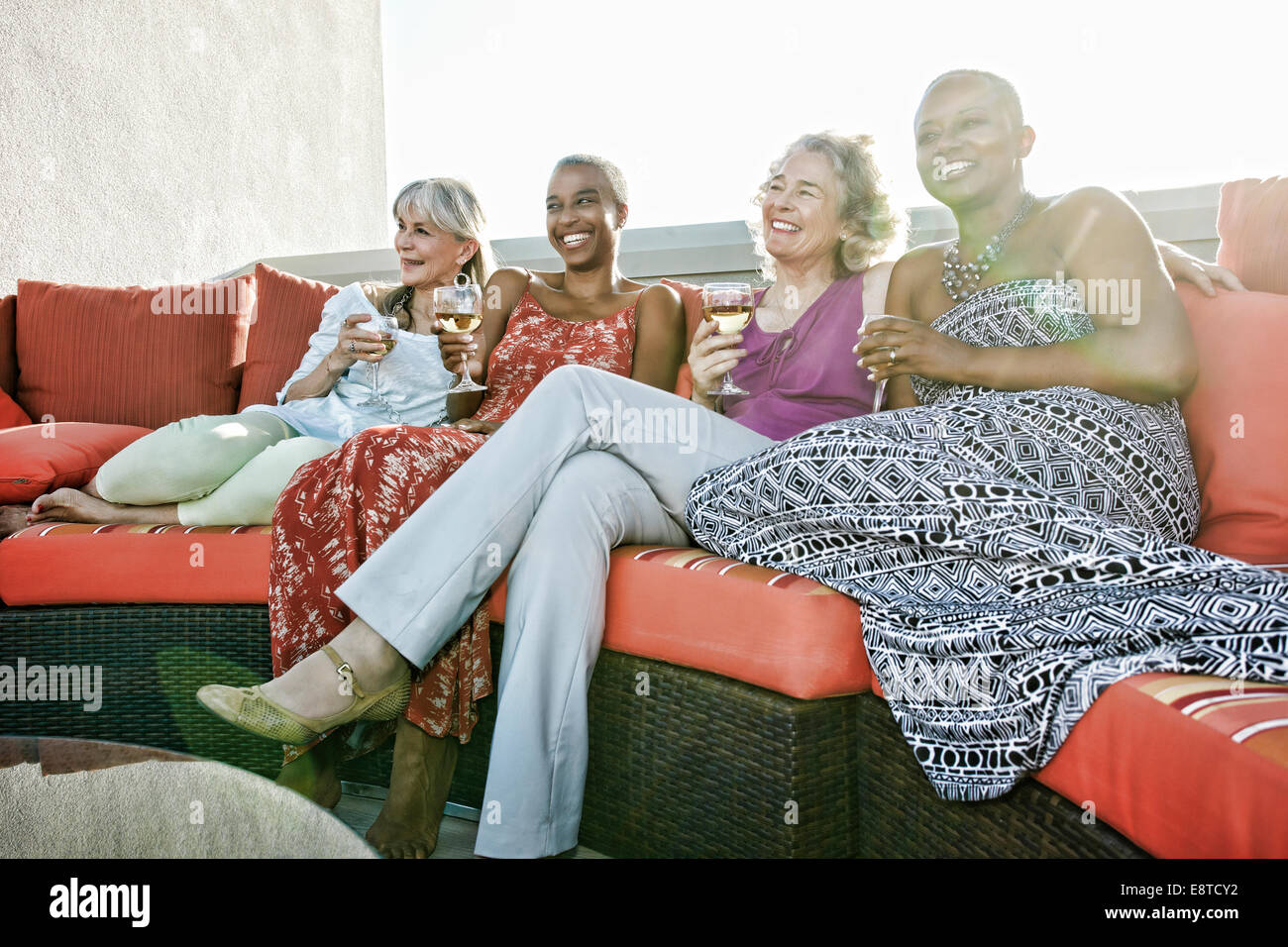 Women drinking wine together on urban rooftop Stock Photo