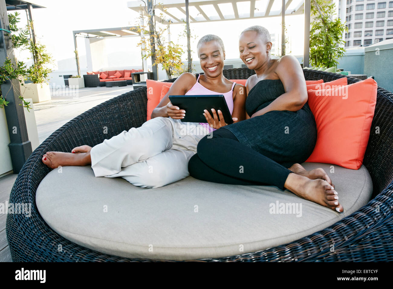 Black women using digital tablet together on urban rooftop Stock Photo