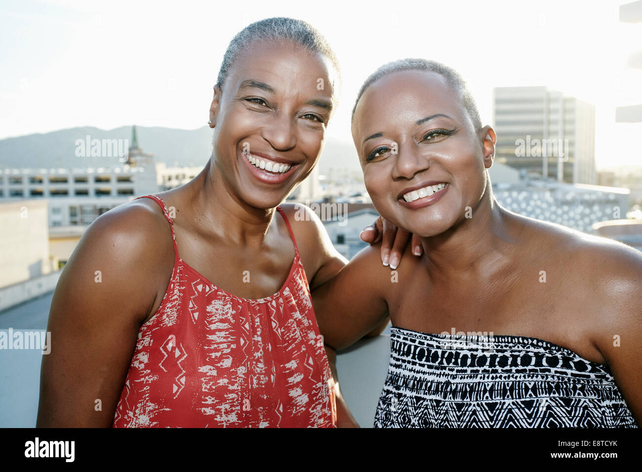 Black women smiling together on urban rooftop Stock Photo