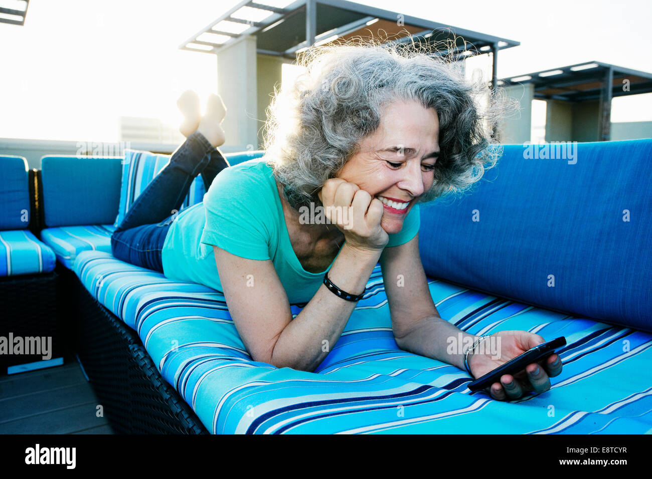 Caucasian woman using cell phone on urban rooftop Stock Photo
