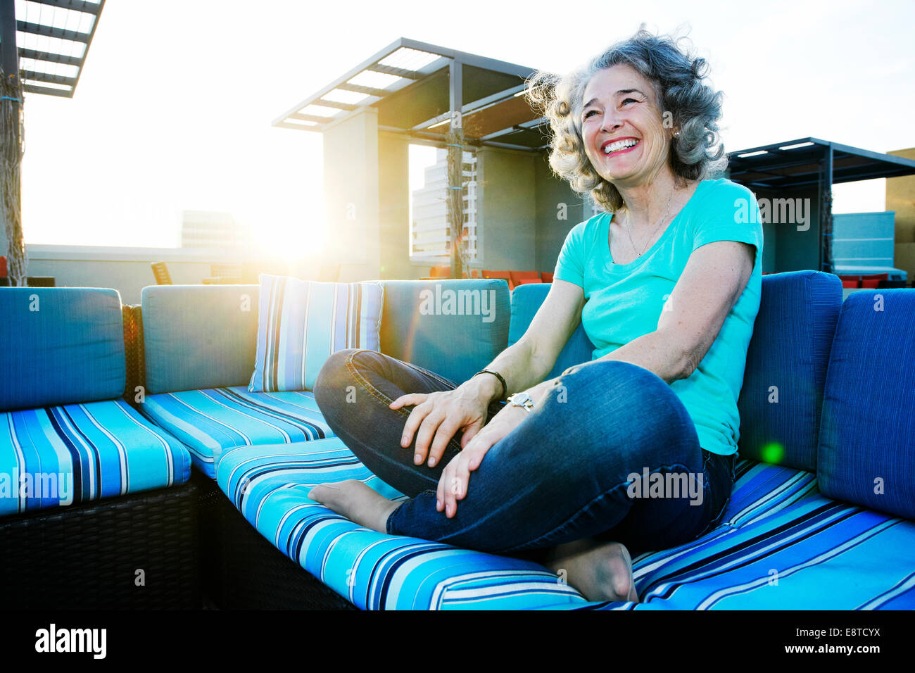 Caucasian woman relaxing on urban rooftop Stock Photo