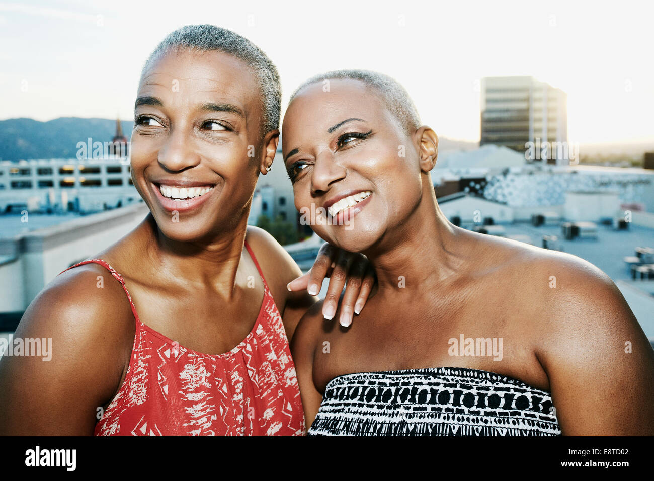 Black women smiling on urban rooftop Stock Photo