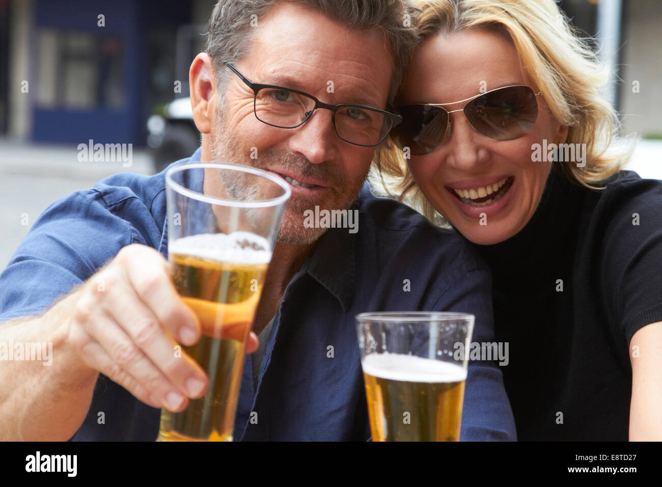 Caucasian couple drinking beer outdoors Stock Photo