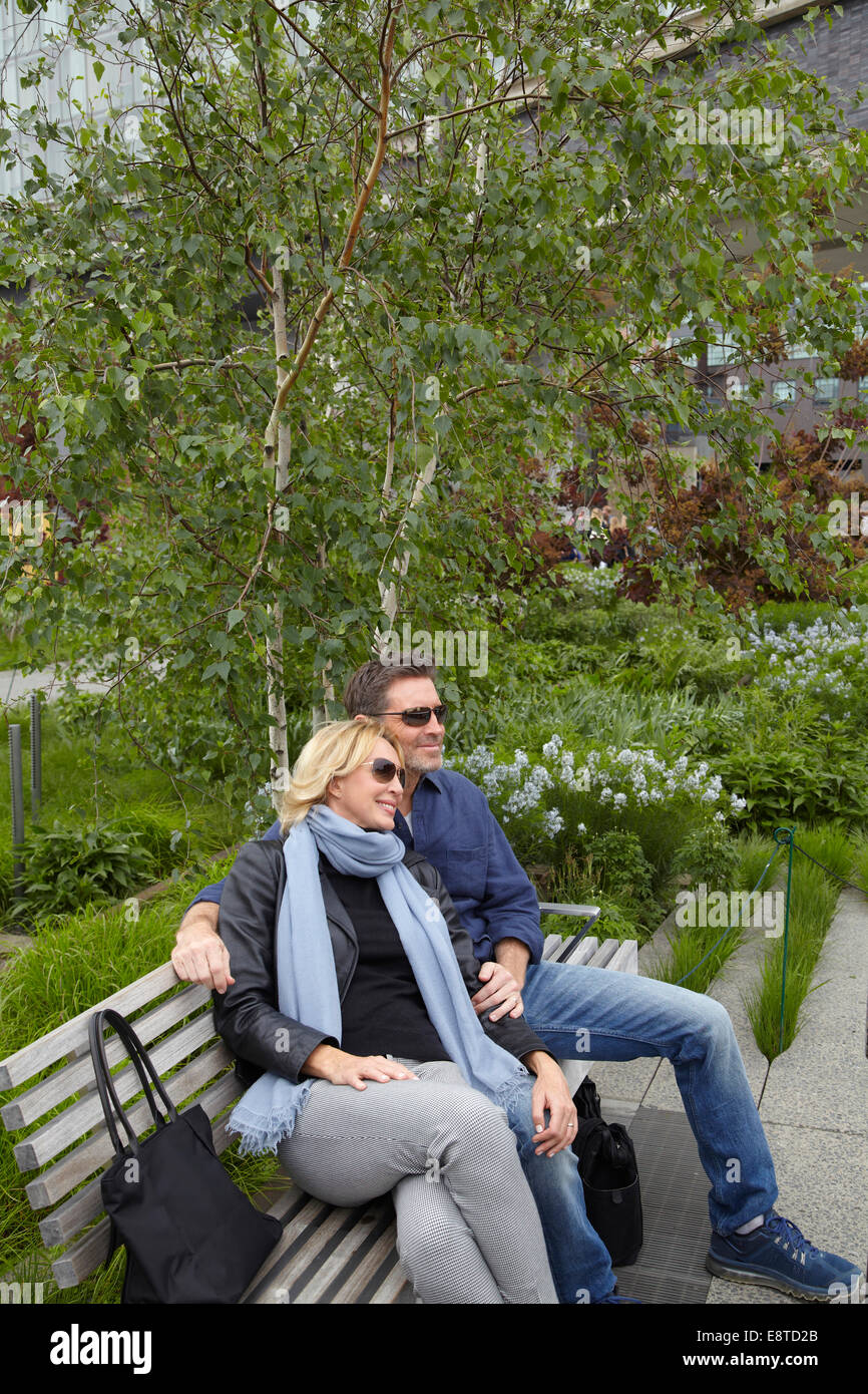 Caucasian couple relaxing on bench in park Stock Photo