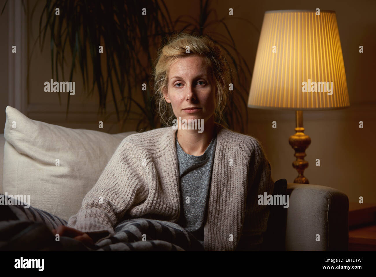 A portrait of a woman sitting on a sofa Stock Photo - Alamy