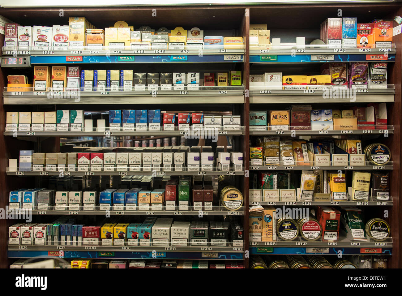 Inside displays of a tobacconist shop that sells cigarettes, lose tobacco, pipe tobacco and papers in a specialist shop Stock Photo