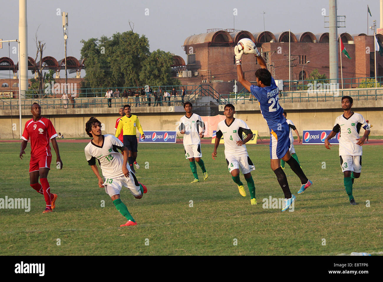 Lahore, Pakistan. 12th October, 2014. Players of Pakistan (white) and Palestine (red ) struggling to get hold on the ball during FIFA Day International Friendly Football Match played at Punjab Football Stadium in Lahore. © Rana Sajid Hussain/Pacific Press/Alamy Live News Stock Photo