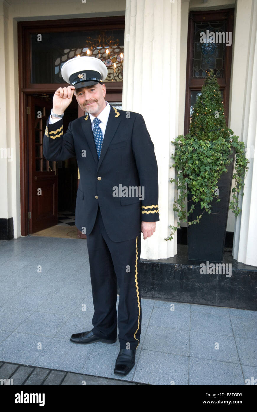hotel reception with concierge in uniform, welcoming guests, outside and  inside the hotel Stock Photo - Alamy