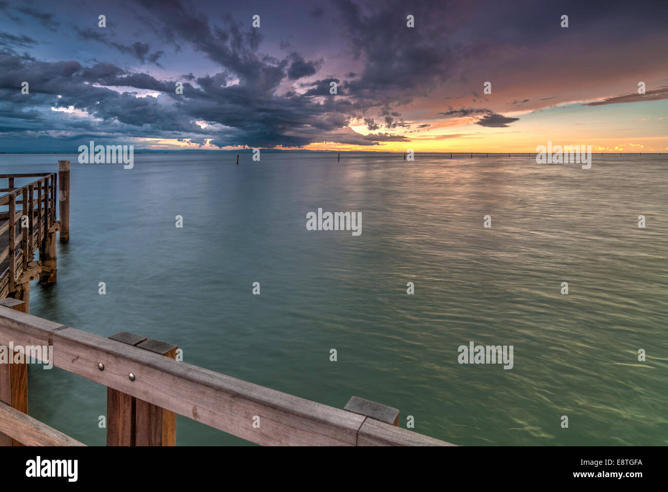 View from wooden pier over the sea with dramatic sky in the background Stock Photo