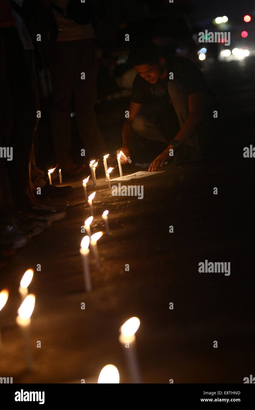 Manila, Philippines. 14th Oct, 2014. An activist lights candles during a candlelighting rally in Manila, Philippines on Oct. 14, 2014. The Philippine government on Tuesday vowed justice for a Filipino transgender who was found dead in a hotel in Olongapo City in northern Philippines. A U.S. Marine, identified as Private First Class Joseph Scott Pemberton, was tagged as a possible suspect in the murder of Jeffrey Laude. Credit:  Rouelle Umali/Xinhua/Alamy Live News Stock Photo