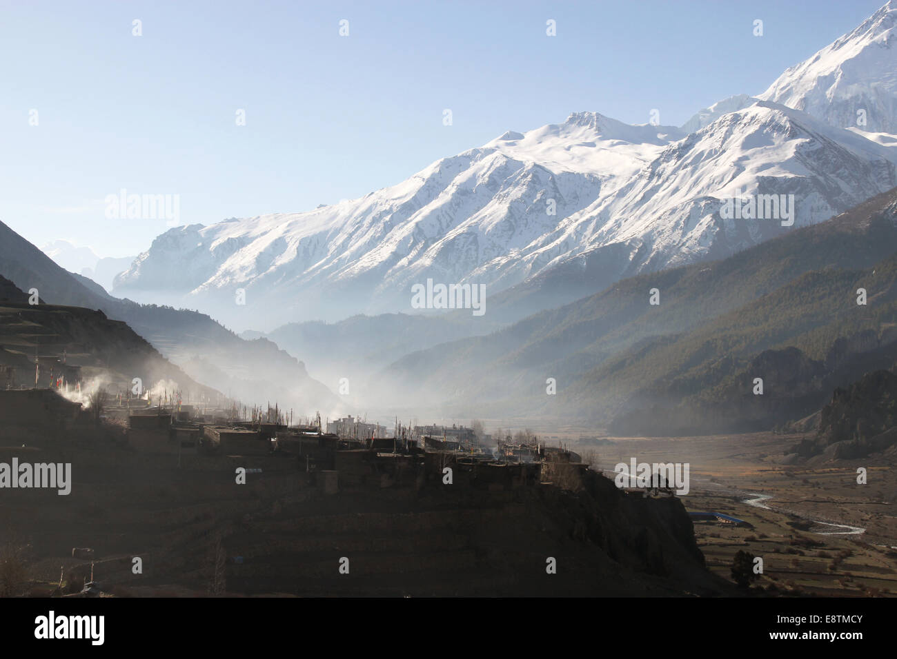 Early morning mist and smoke over the town of  Manang,Manang Valley, Nepal Stock Photo
