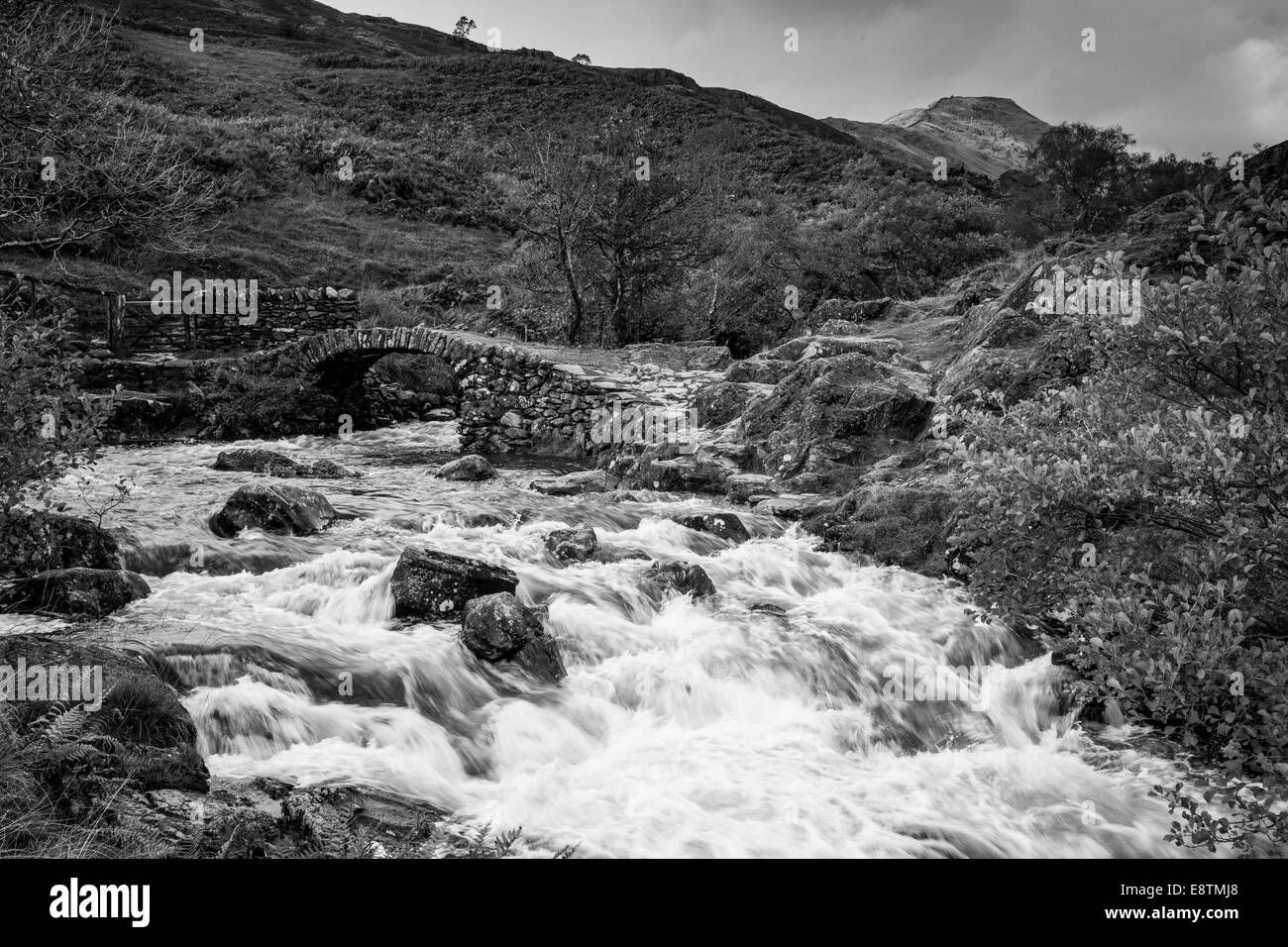 The Scandale Beck flowing under High Sweden Bridge, (with High Pike in the background) above Ambleside, Lake District, Cumbria Stock Photo