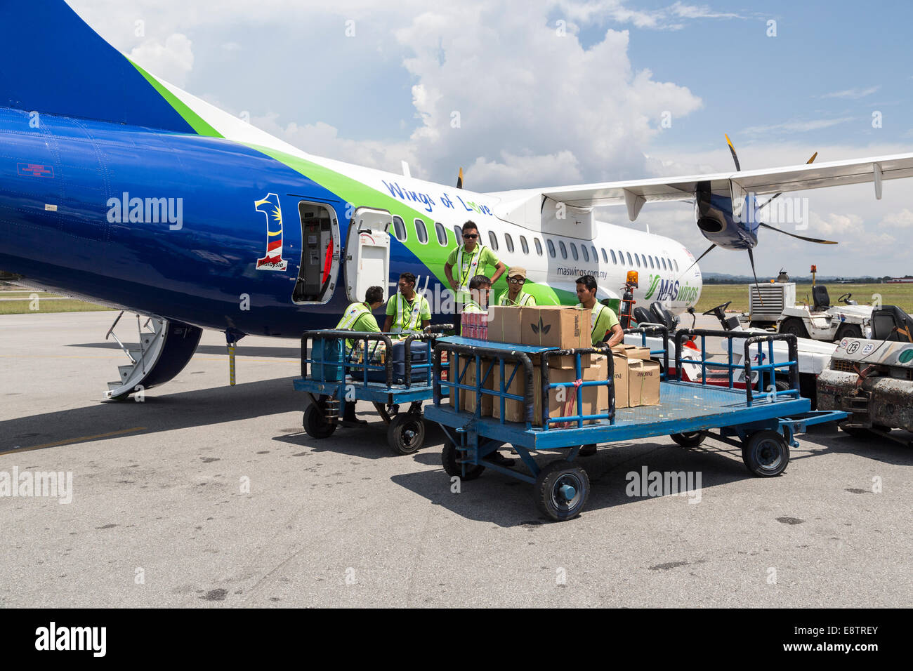 Baggage being loaded into plane for MAS Wings flight, Miri airport, Malaysia Stock Photo