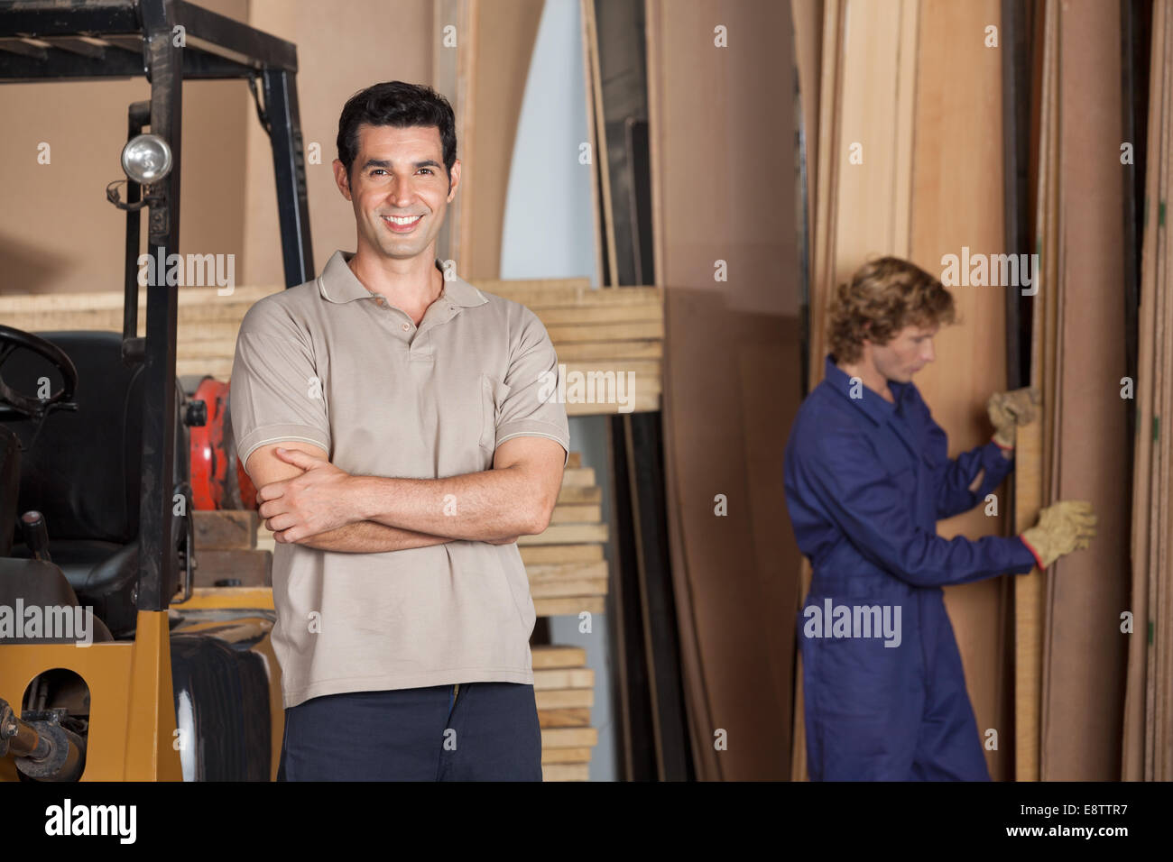 Carpenter With Arms Crossed In Workshop Stock Photo
