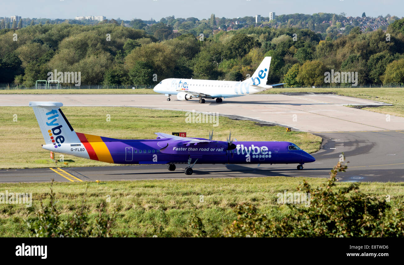 Flybe DHC Dash 8 and Embraer ERJ-170 aircraft taxiing at Birmingham Airport, UK Stock Photo