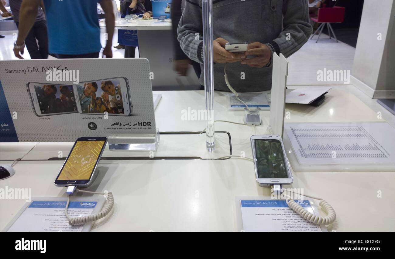 Tehran, Iran. 14th Oct, 2014. October 14, 2014 - Tehran, Iran - An Iranian customer tries out a Samsung Galaxy S5 smartphone at a Samsung store in a multimedia and computer shopping center in southern Tehran. Morteza Nikoubazl/ZUMAPRESS © Morteza Nikoubazl/ZUMA Wire/Alamy Live News Stock Photo