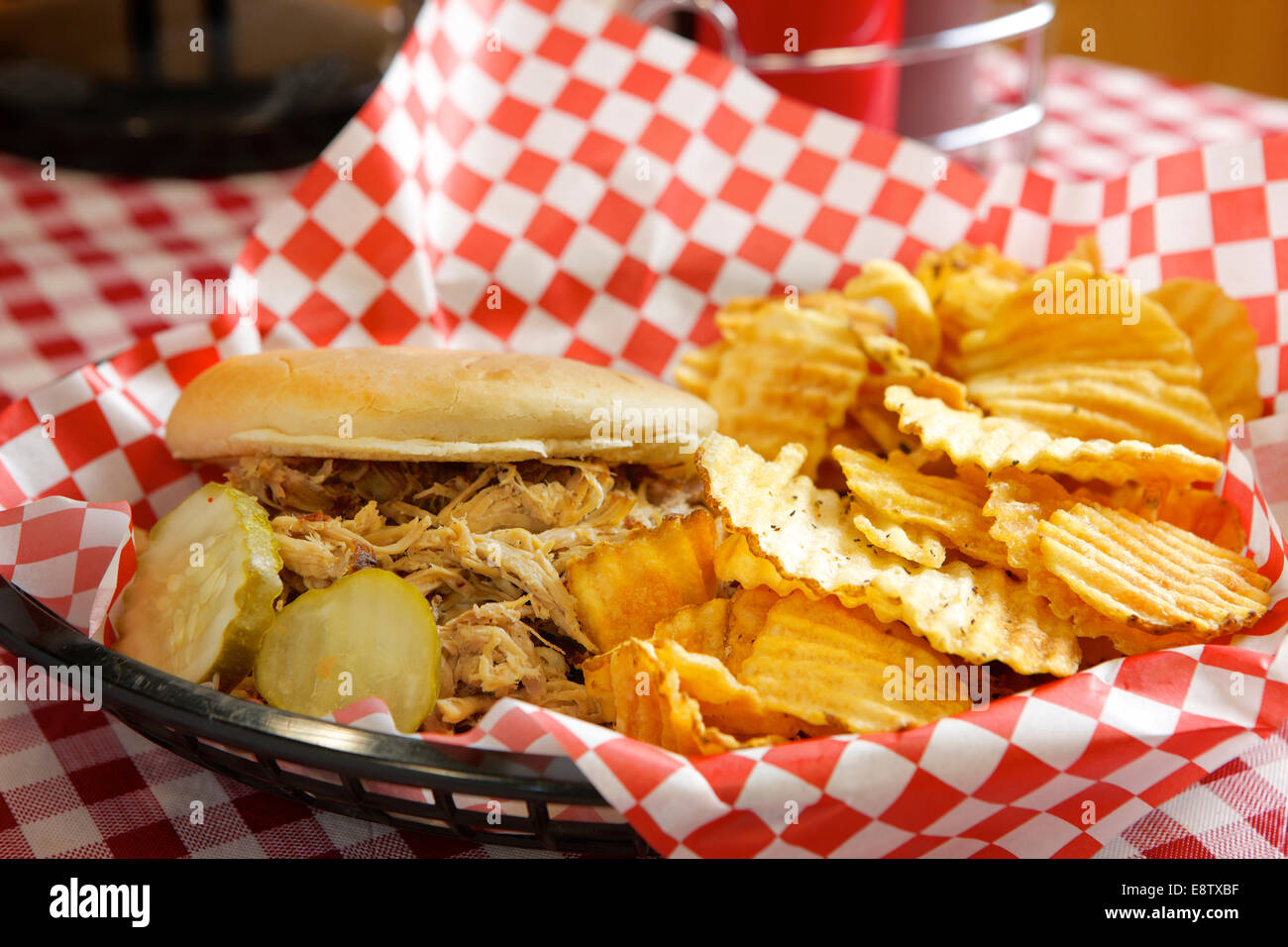 A pulled pork sandwich with potato chips and pickles Stock Photo Alamy