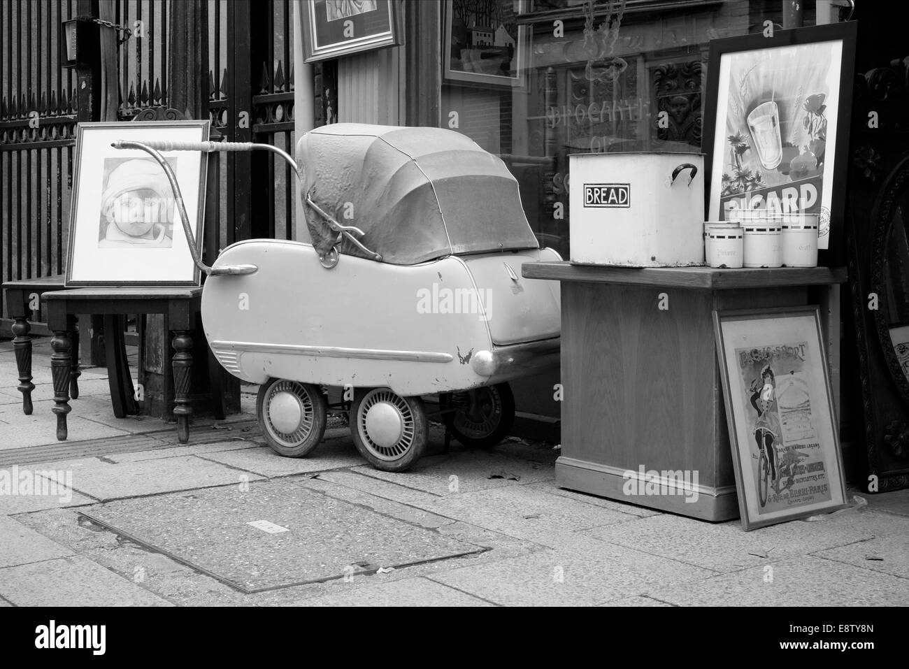 antiques and curios including an old pram displayed for sale outside of a shop england uk Stock Photo