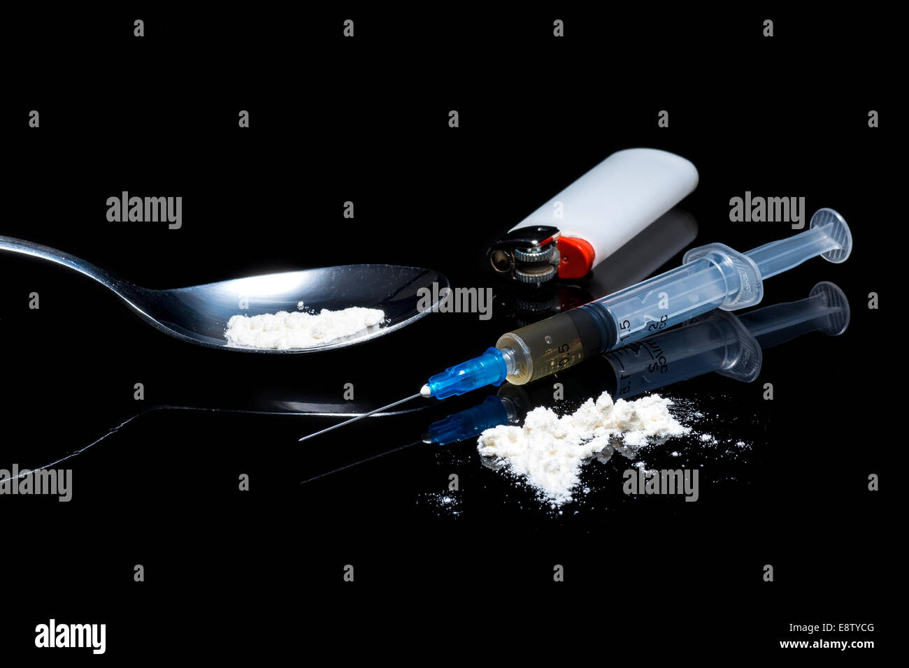Drug syringe and cooked heroin on spoon on the black background Stock Photo
