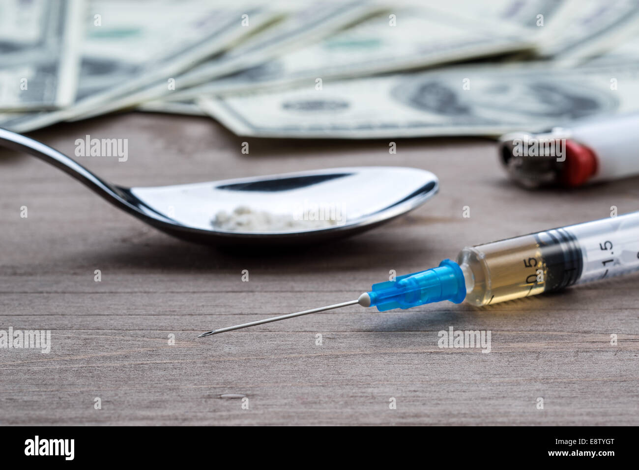 Drug syringe, cooked heroin on spoon and money Stock Photo