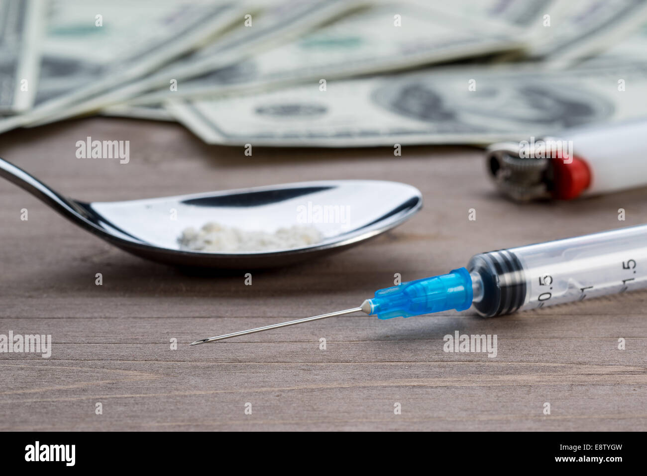 Drug syringe, cooked heroin on spoon and money Stock Photo