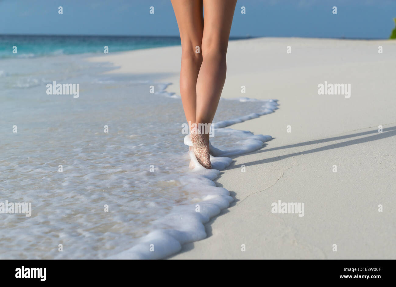 Beach travel - woman walking on sand beach leaving footprints in the ...