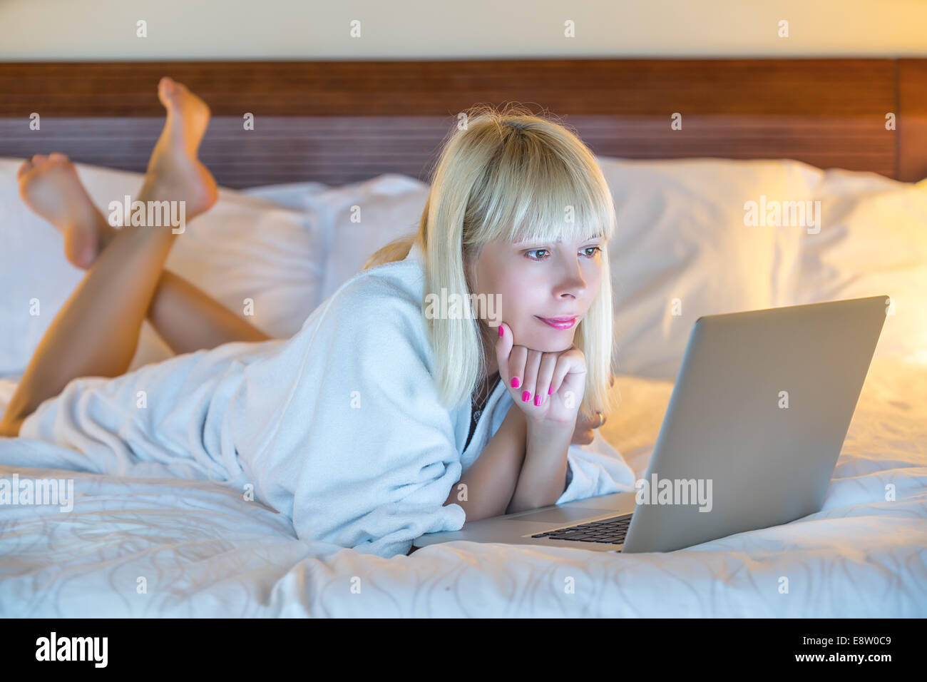 Portrait of a relaxed young woman using laptop in bed at home Stock Photo