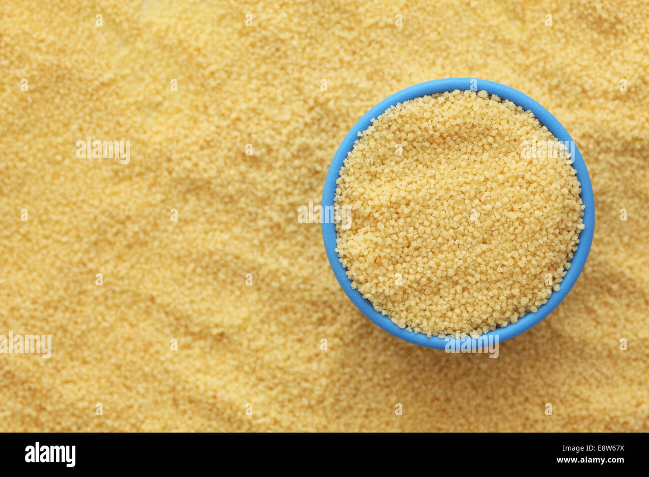 Couscous in a blue bowl on couscous background. Close-up. Stock Photo