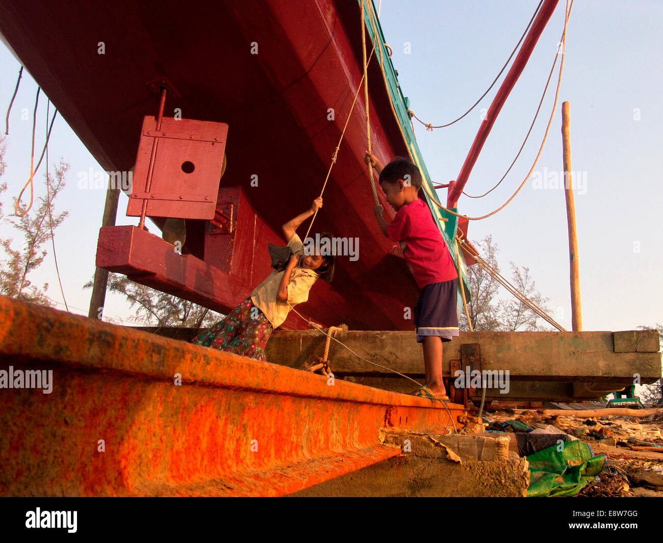 Children,kids,play under fishing boat,we are the future,we love having fun. Stock Photo