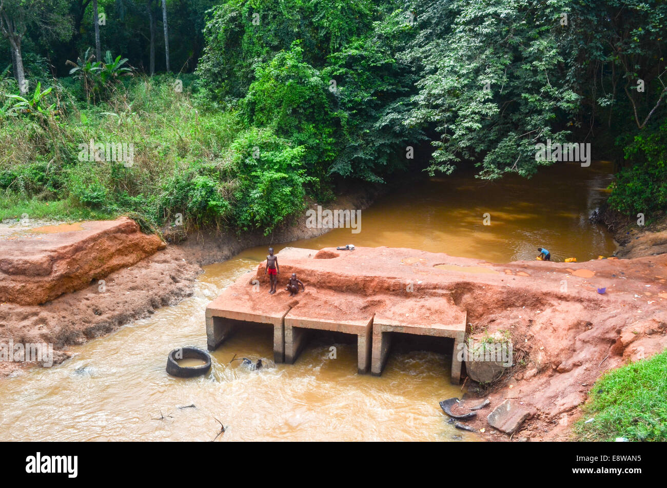 Poor infrastructure in Nigeria, dirt roads, floods and kids playing with unfinished bridges Stock Photo