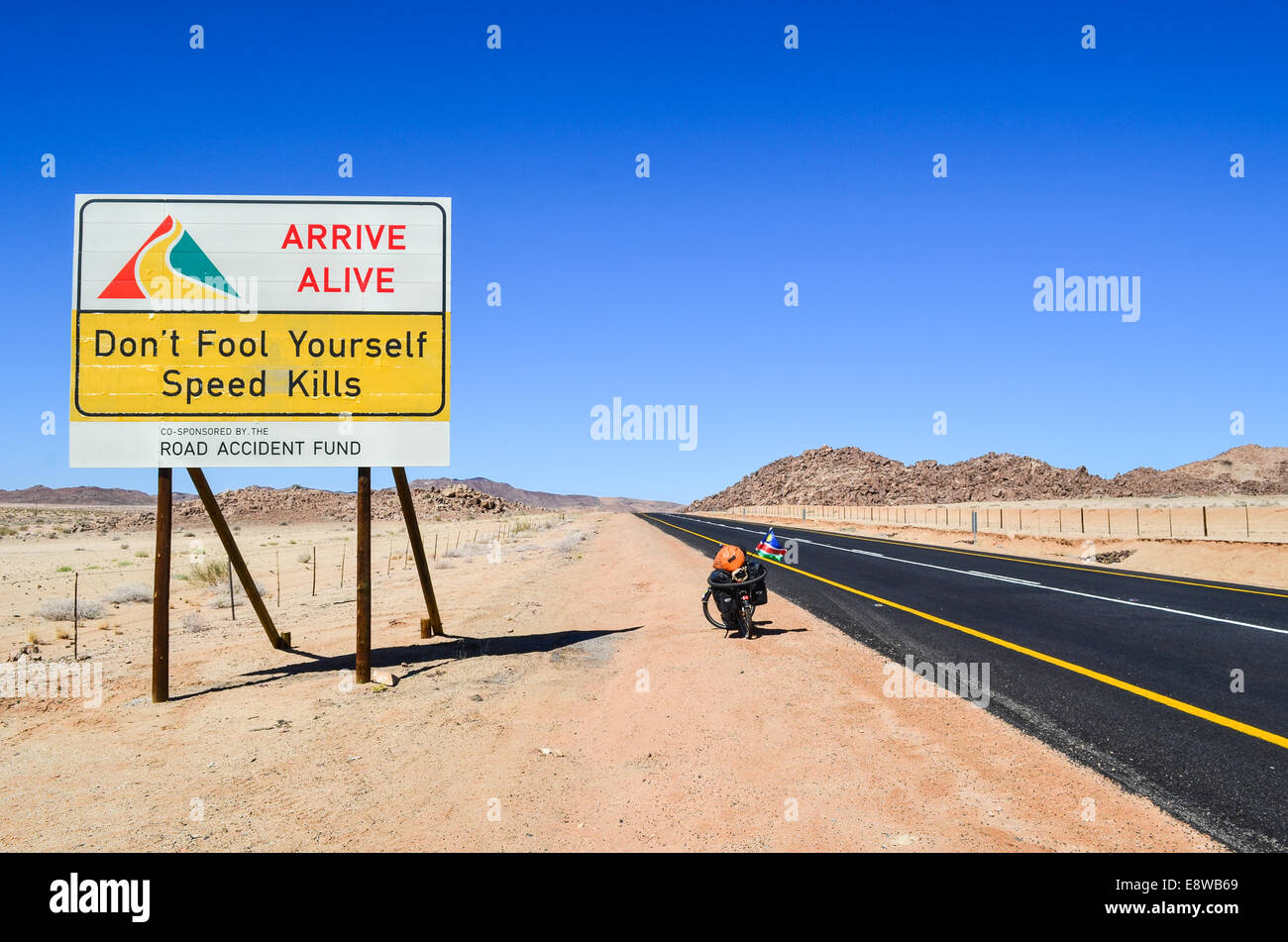 Road safety sign in South Africa, Northern Cape, reading 'Don't fool yourself, Speed kills' and a bicycle Stock Photo