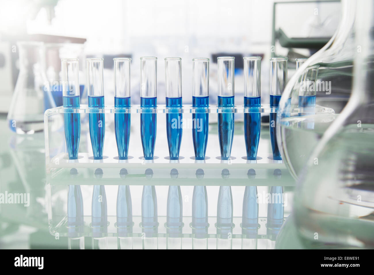 Rack of test tubes with solution on counter in lab Stock Photo