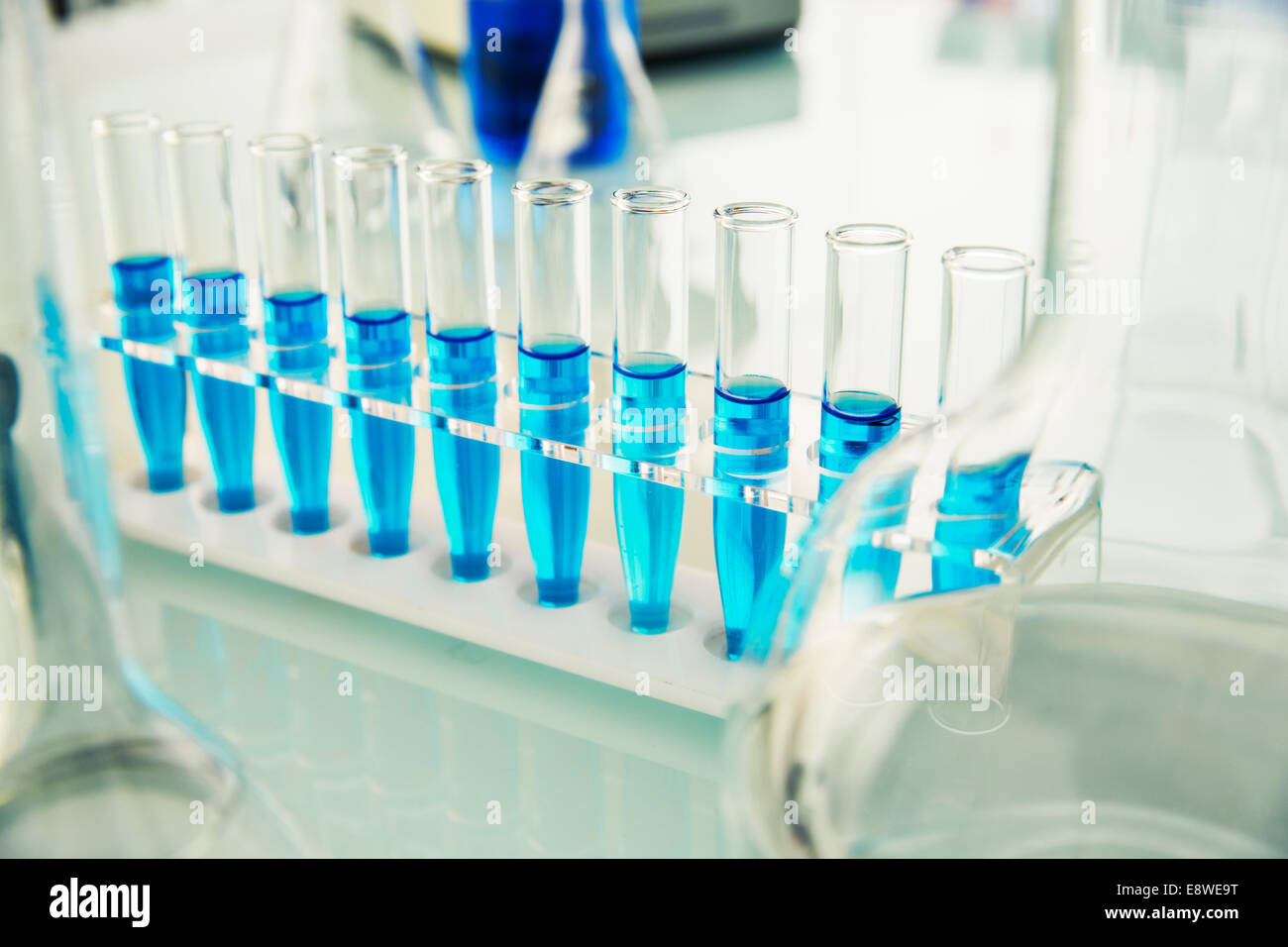 Rack of test tubes with solution on counter in lab Stock Photo