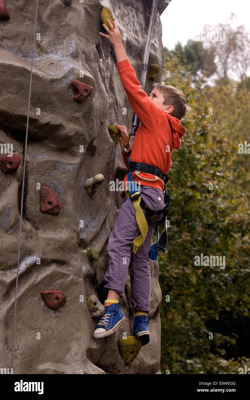 Young boy attempting the climbing wall at a farm open day, Blackmoor, Hampshire, UK. Stock Photo