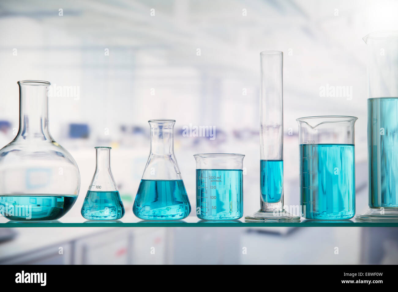 Beakers with solution on shelf in lab Stock Photo Alamy