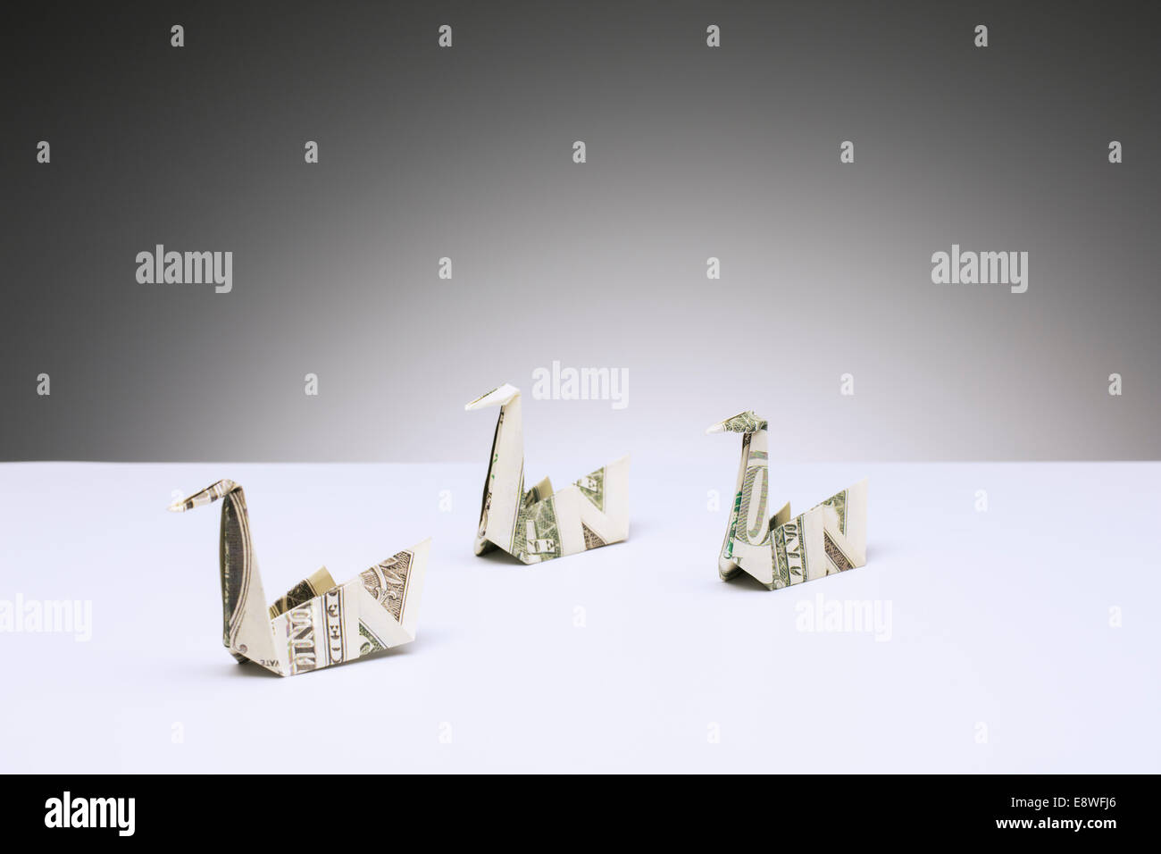 Origami swans made of dollar bills on counter Stock Photo