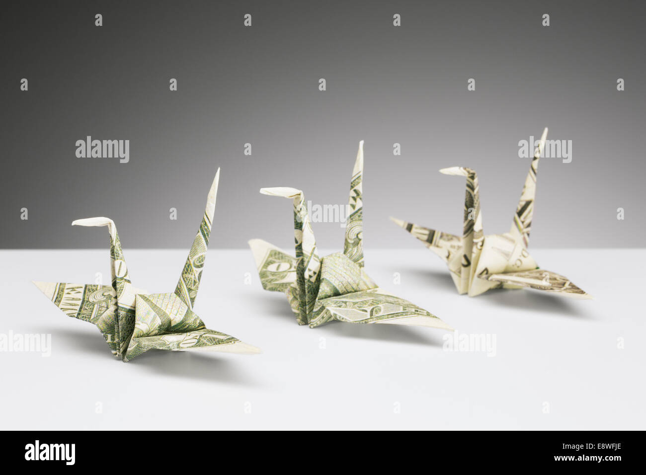 Origami cranes made of dollar bills on counter Stock Photo