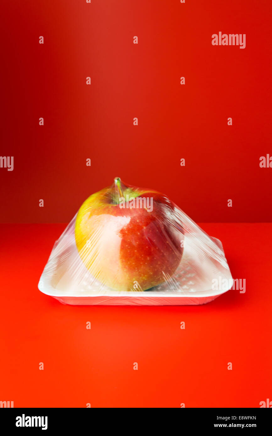 Close up of apple shrink wrapped in plastic Stock Photo