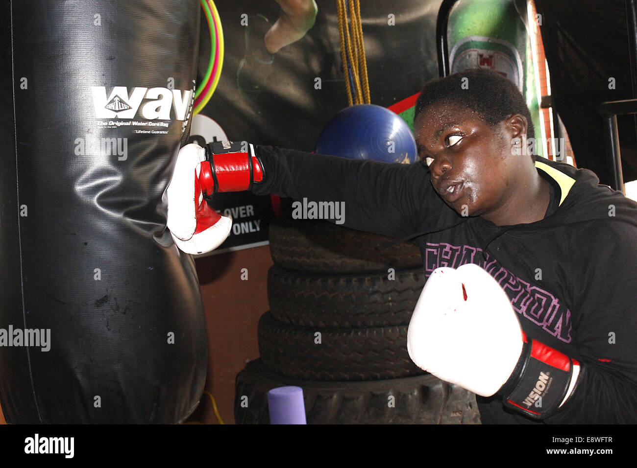 Kampala, Uganda. 15th October, 2014. A Ugandan woman boxer loading punching power in preparation for the World Championships due in South Korea on November 13-25. Despite luck of income, most boxers carry on traning with the hope of gaining fame through the sport. Credit:  Samson Opus/Alamy Live News Stock Photo