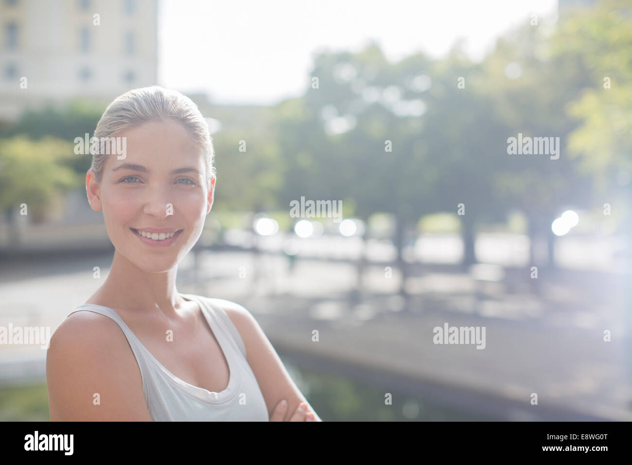 Woman smiling on city streets Stock Photo