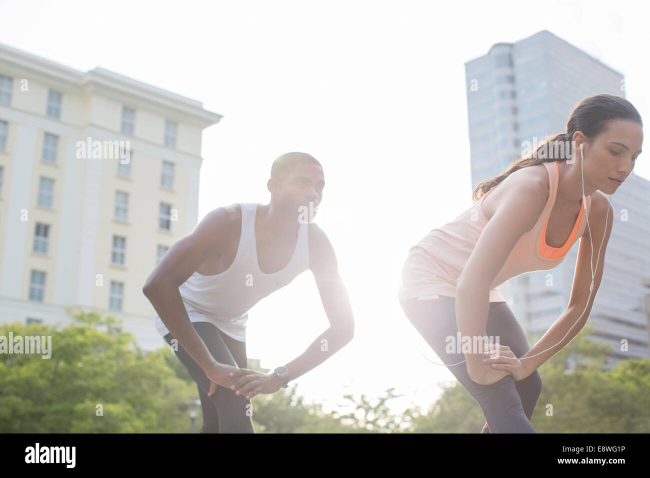Couple stretching before exercising on city street Stock Photo