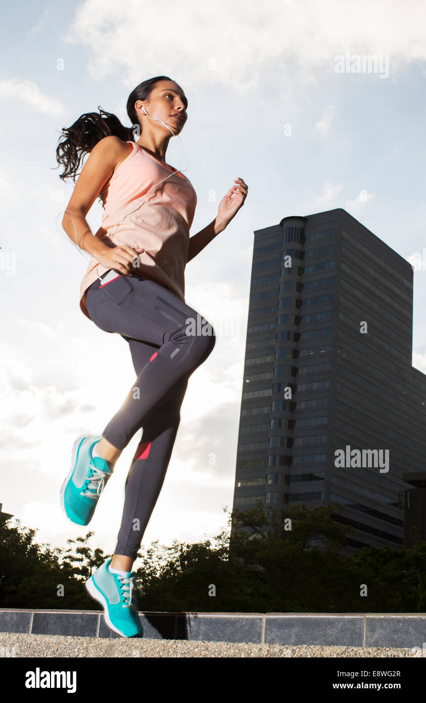 Woman exercising on city streets Stock Photo