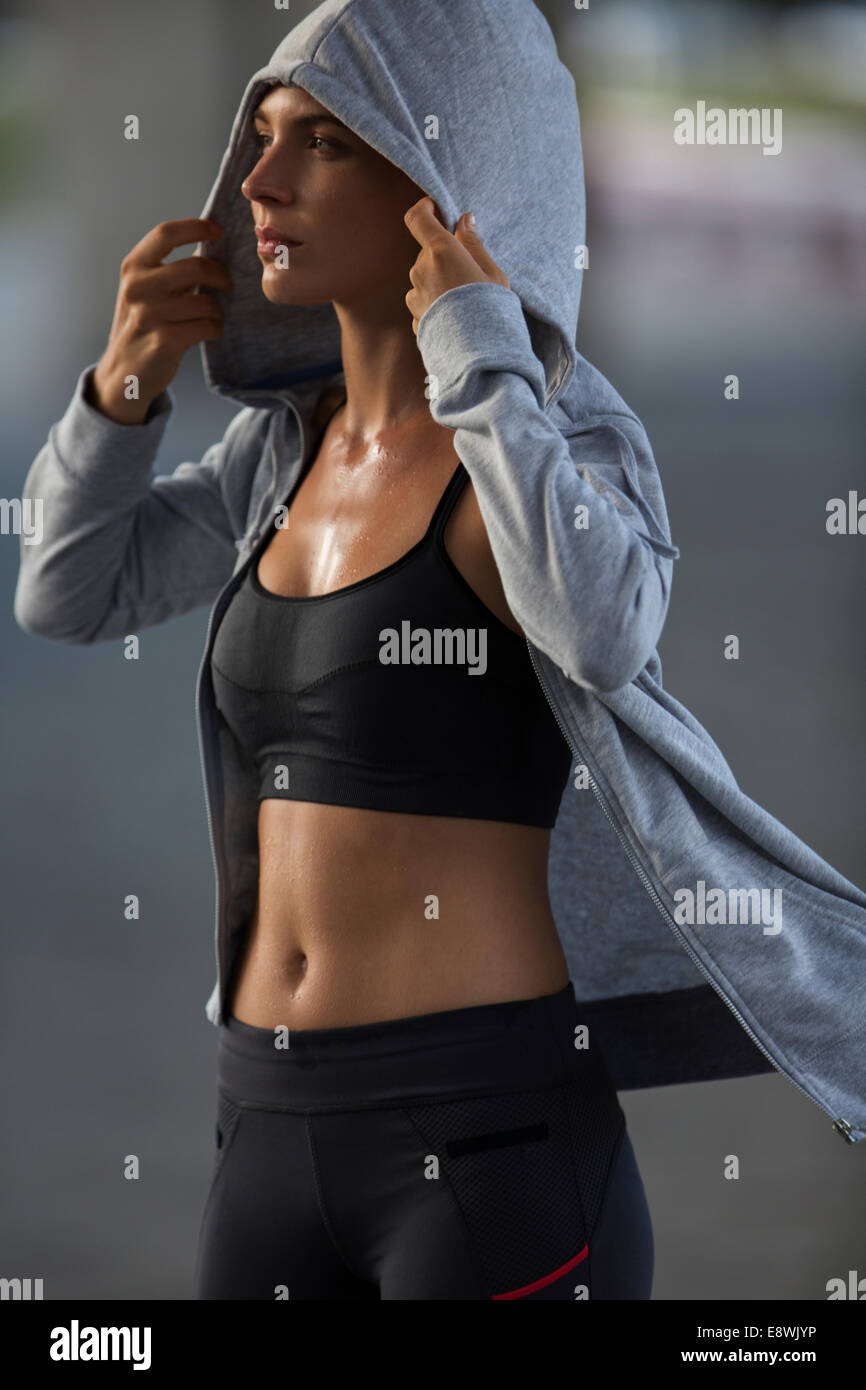 Woman putting on sweatshirt after exercise Stock Photo