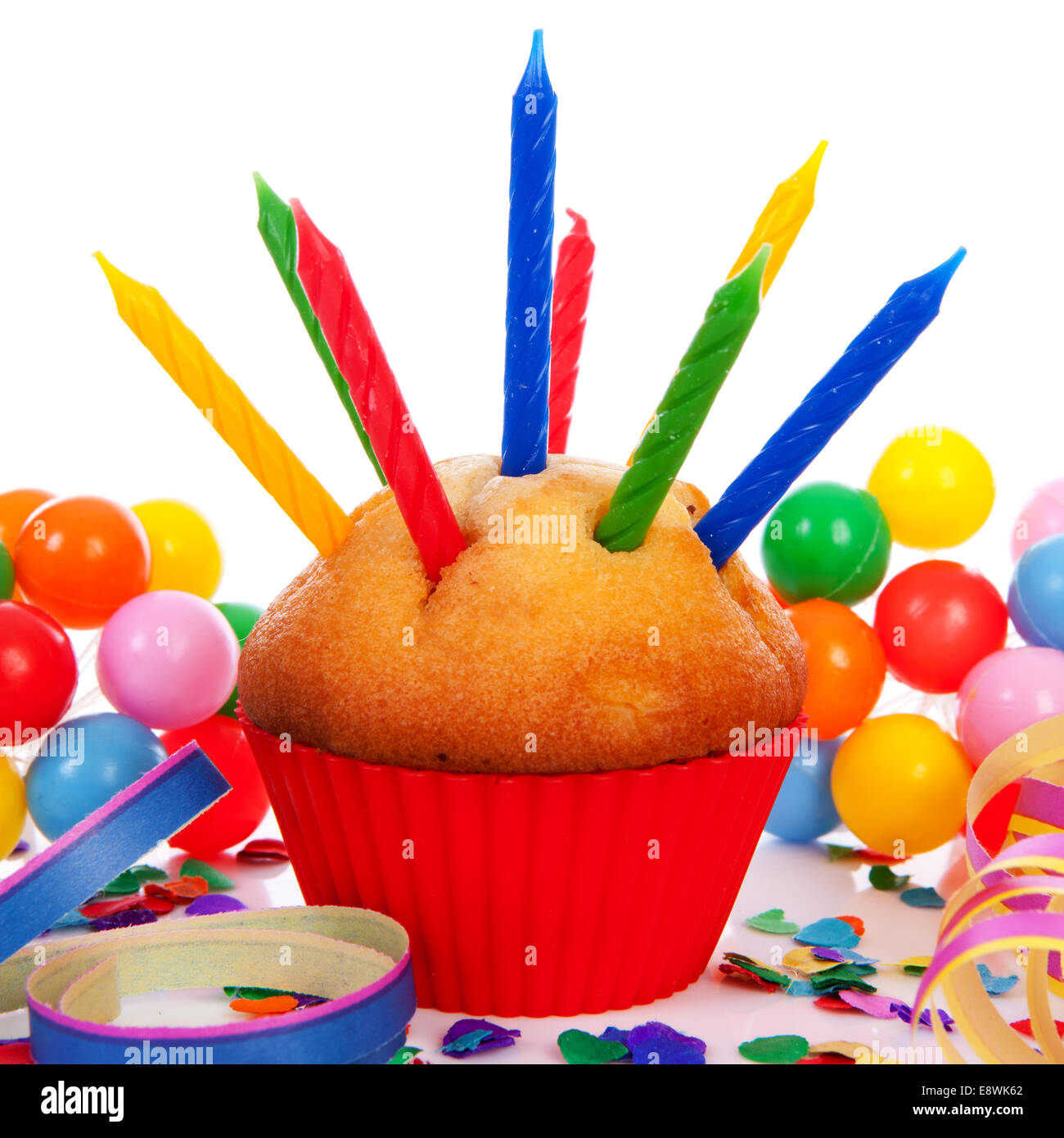 Birthday cupcake with lots of candles, party streamers and colorful